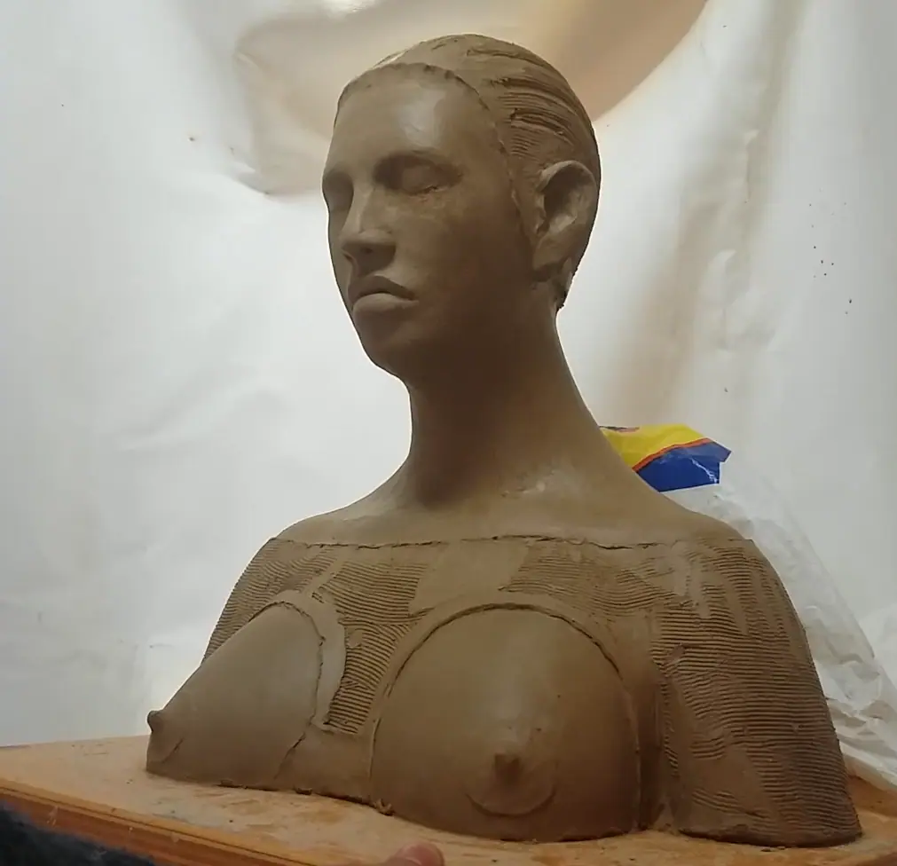 Escultura femenina en barro, vista 3/4, símbolo de lucha y dignidad – Nodriza Eónica, obra de Juan Up
